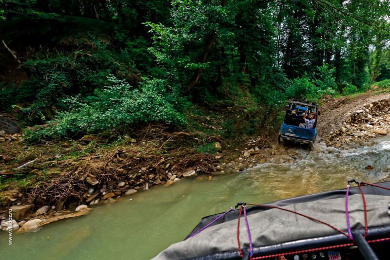 Off-road mountain tour through the canyons of the Psaho river, Sochi, Russia. Off-road car with passengers is going to the mountains.