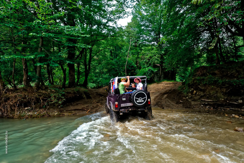 Off-road mountain tour through the canyons of the Psaho river, Sochi, Russia. Off-road car with passengers is going to the mountains.