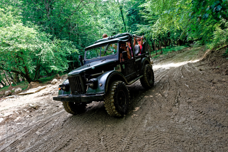 Off-road mountain tour through the canyons of the Psaho river, Sochi, Russia. Off-road car with passengers is going to the mountains.